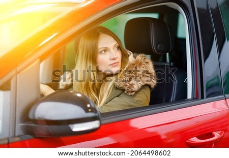 Young attractive woman with happy positive expression, being satisfied with unforgettable journey by car, sits on driver seat. People, driving, transport concept. Winter ski holiday by car