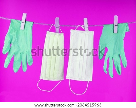 Disposable gloves  on a rope . Disposable gloves are used once . Let's say stop the coronavirus. Place for the test.  Medical gloves on a yellow background with copy space. Concept: stop the covid-19