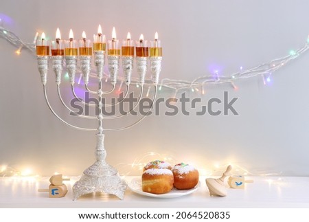Religion image of jewish holiday Hanukkah background with menorah (traditional candelabra), doughnuts, spinning top and oil candles
