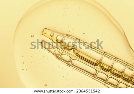 Liquid pipette serum pink gel on light yellow mirror background Royalty-Free Stock Photo #2064531542