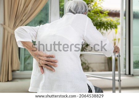 Asian senior patient with lower back pain or back muscle injury,old elderly having backache,painful of spinal joint,inflammation and degeneration of the spine and intervertebral discs,health problems