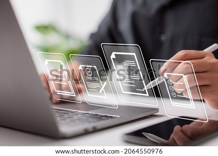 Paperless workplace idea, e-signing, electronic signature, document management. A businessman signs an electronic document on a digital document on a virtual notebook screen using a stylus pen.  Royalty-Free Stock Photo #2064550976