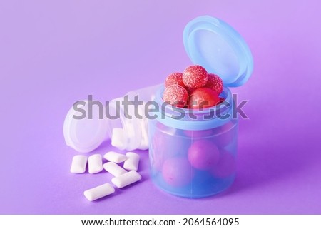 Jars with tasty chewing gums on color background