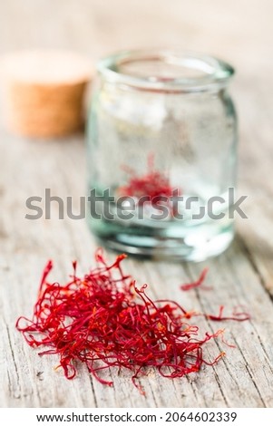 Saffron threads in jar on wooden table