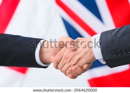 Business people handshaking against the flags of Great Britain and England