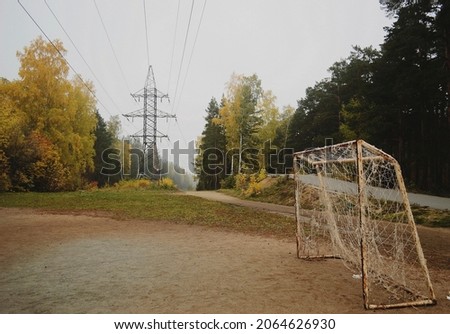 Football goal and power line in autumn forest