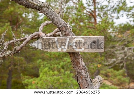 Wooden WC sign in the forest, Raseborg, Finland