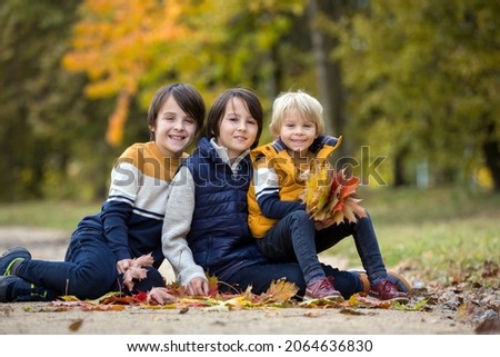 Happy family, funny children, having their autumn pictures taken in the park, children playing