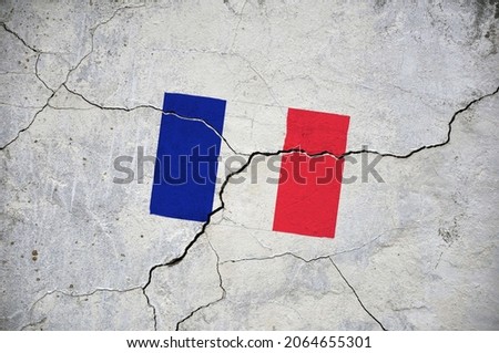 An old image of the flag of France on a wall with a crack. A crisis.