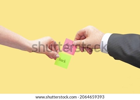 Two hands hold two sticky notes with the words Do Not Look Back. Conceptual image of a motivating statement, a call not to look back at the past and move forward.