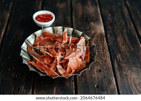 Dried chicken, dried poultry, cut into strips on a plate on a wooden background. High quality photo