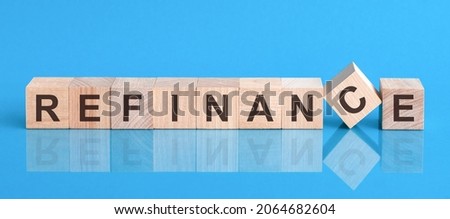 refinance word written on wood block. reduction word is made of wooden building blocks lying on the blue table. Business concept