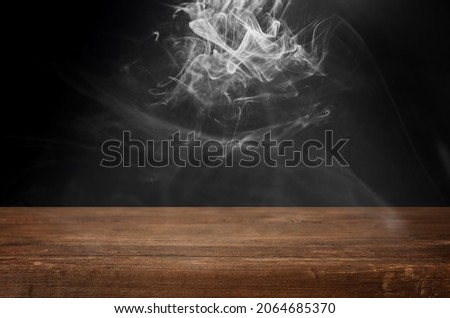 empty wooden table with clouds of smoke