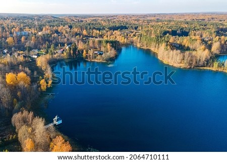 A small village of Tervenichi, autumn Forest and a lake with a font, Russia, Leningrad region. Royalty-Free Stock Photo #2064710111
