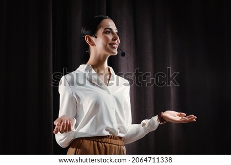 Motivational speaker with headset performing on stage Royalty-Free Stock Photo #2064711338