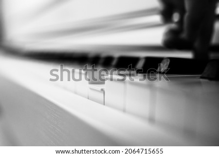 Piano keys and one pressed. Black and white photo. Abstract photo.