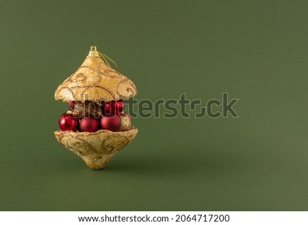 Creative composition of burger made of red and gold   Christmas ornament balls against green background. Minimal New Year concept. Copy space.