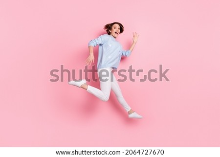 Full size photo of smiling crazy excited girl jumping showing hands say hello greetings isolated on pink color background