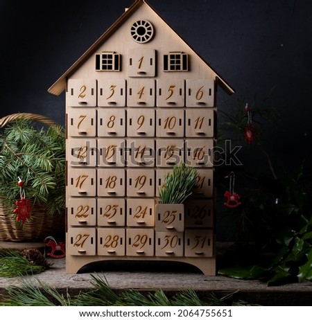 Wooden advent calendar for waiting new year or christmas. Box with cells from 1 to 25 and 31 for mini gifts. December atmosphere and decor.