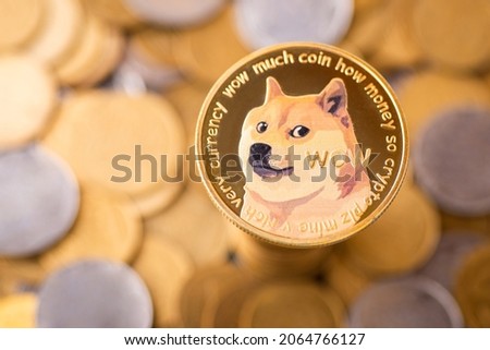 The golden Dogecoin with background of regular coins. Dogecoin cryptocurrency symbol Royalty-Free Stock Photo #2064766127