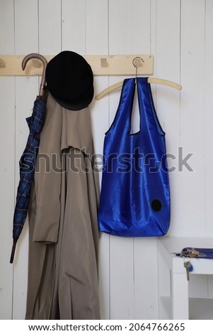 blue eco bag or shopper hanging on a hanger, decoration around, ecological consciousness, white background