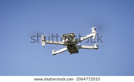 White Drone Flying on Nature Background. Drone Hanging in Air Flying Helicopter Dron  Remote Control Air Drone