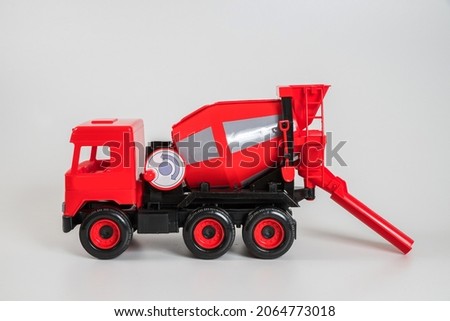 Multi-colored plastic children's toy cars on a white background. Red concrete truck.