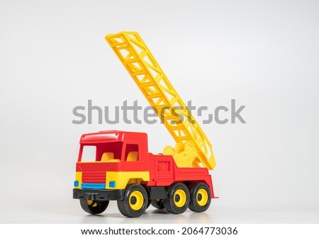 Children's toy plastic car isolated on white background. Red fire truck.