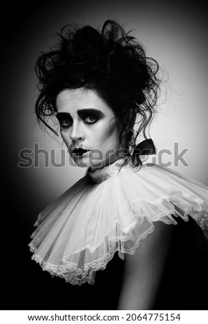 Sad expression. Black and white portrait of attractive woman in artistic costume for party, with creepy makeup isolated over black background. Concept of party, costume, creativity, Halloween, ad