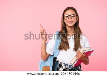 Excellent best student schoolgirl pointing with her fingers showing copy space wearing school bag isolated in pink background Royalty-Free Stock Photo #2064801446