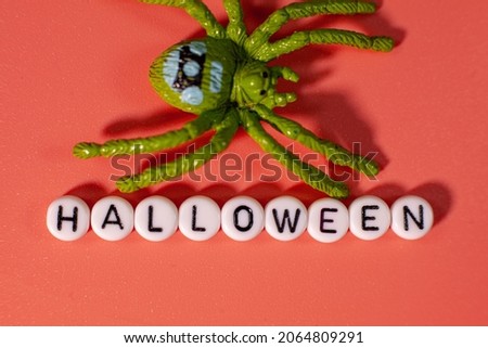 Letter chain name and spider on the table, Halloween name on a pink background.