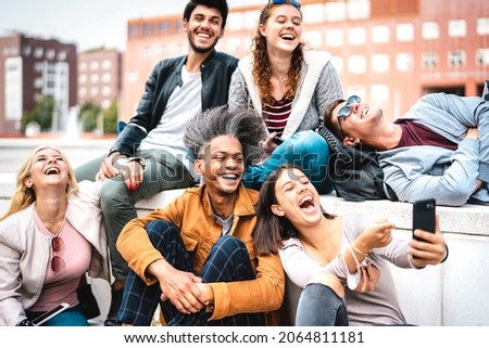 Happy milenial friends having fun with mobile phone at campus college yard - Joyful guys and girls spending tech time together at university lecture break - Warm bright filter with focus on lower guy Royalty-Free Stock Photo #2064811181