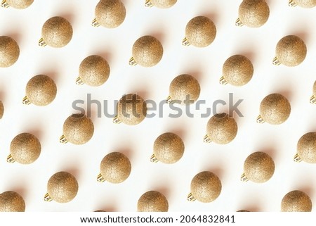 Minimal Christmas concept. Creative Christmas pattern made with gold yellow christmas ball decoration on a white background. Abstract background. Top view, flat lay.