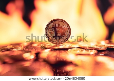 Close up - Bitcoin Crypto currency gold coin on fire background. Blockchain technology, Virtual cryptocurrency concept.
