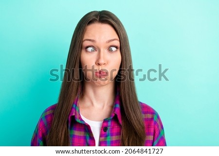 Portrait of attractive funky girl wearing checked shirt grimacing fooling isolated over bright teal green color background