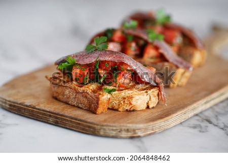 Toast tapas with anchovies, tomato, parsley on bread   Royalty-Free Stock Photo #2064848462