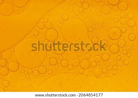 Colorful oil drops on the water surface
Water in oil in abstract style on color background. blue liquid splash. Golden yellow bubble oil abstract background.