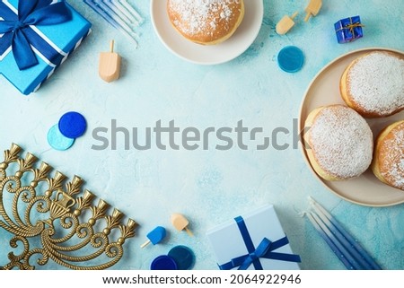 Frame border design for Jewish holiday Hanukkah with traditional donuts, menorah and gift box. Top view, flat lay