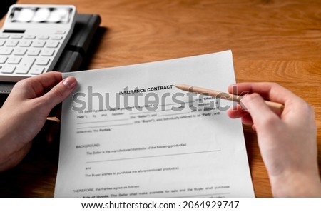Insurance contract concept. Paper document, agreement in hands POV.