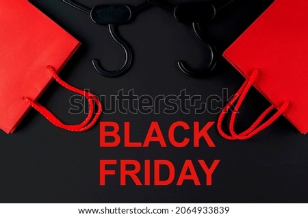 Black hanger and red bag on the black background. Black friday text