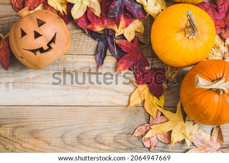 Halloween autumn background greeting card with colorful leaves, pumpkins and lantern. Orange and brown color.