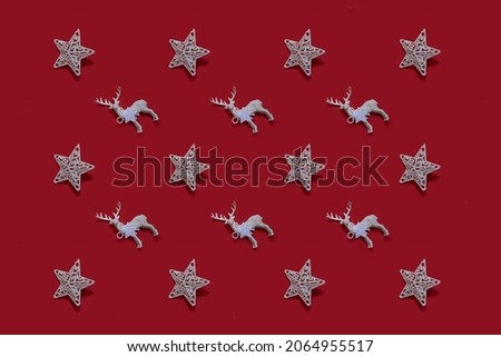 Colorful Christmas star and toy deer pattern on a red background. Minimal Christmas concept. Flat lay
