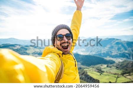 Young hiker man taking selfie portrait on the top of mountain - Happy guy smiling at camera - Hiking, sport, travel and technology concept - Bright filter Royalty-Free Stock Photo #2064959456