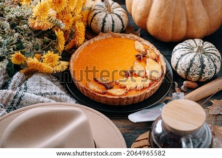 Autumn baking background with pumpkin pie pumpkin yellow autumn leaves on wooden background
