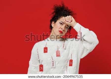 Young sick ill tred exhausted female costumer woman 20s wear white knitted sweater with tags sale in store showroom put hand on forehead have headache isolated on plain red background studio portrait