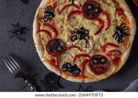 Halloween funny pizza with spiders, Creative idea for Halloween pizza on dark gray background, Top view