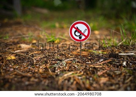 A round sign prohibiting the use of an open fire in nature. Bonfires are prohibited. A flammable area of the forest. A fire-hazardous situation. A crossed out burning match. Royalty-Free Stock Photo #2064980708