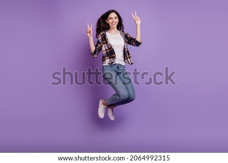 Full length photo of young attractive girl happy positive smile jump up show peace cool v-sign isolated over violet color background