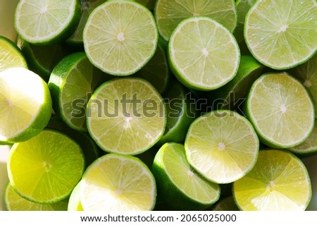 Lime Background with sun light from outside. Close up shot of limes. Selective Focus of sliced lime. Lime is a kind of fruit. The result is very sour for cook the Thai food style Royalty-Free Stock Photo #2065025000