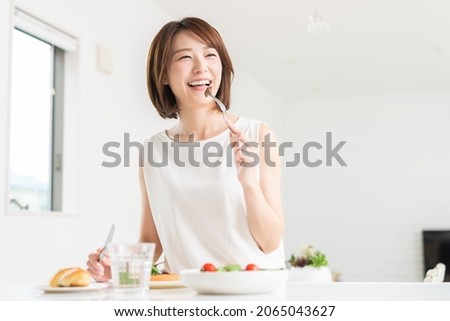 young attractive asian woman who eats Royalty-Free Stock Photo #2065043627